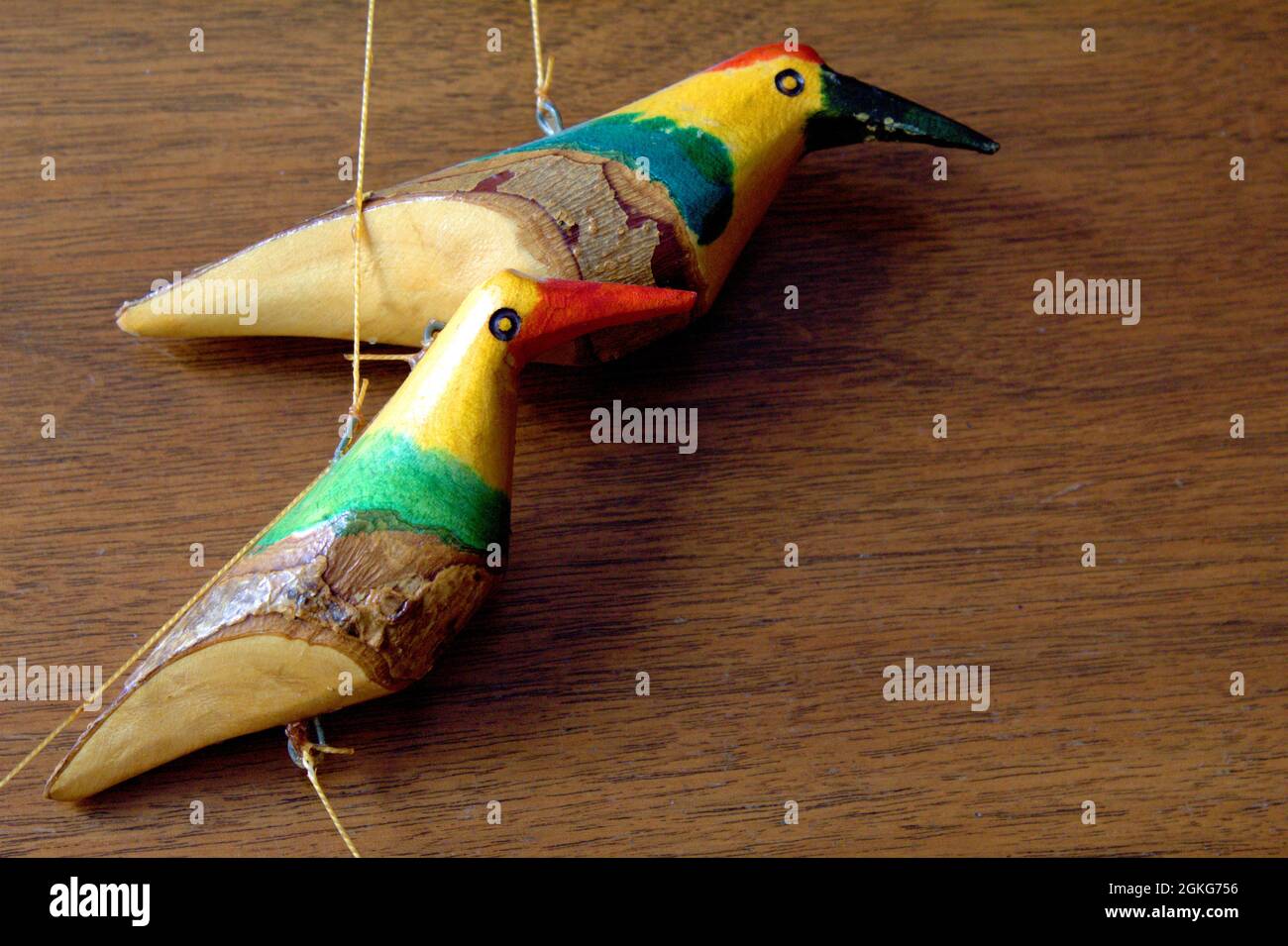Pájaros de madera tallados pintados de un móvil colgante sobre un fondo de  madera Fotografía de stock - Alamy