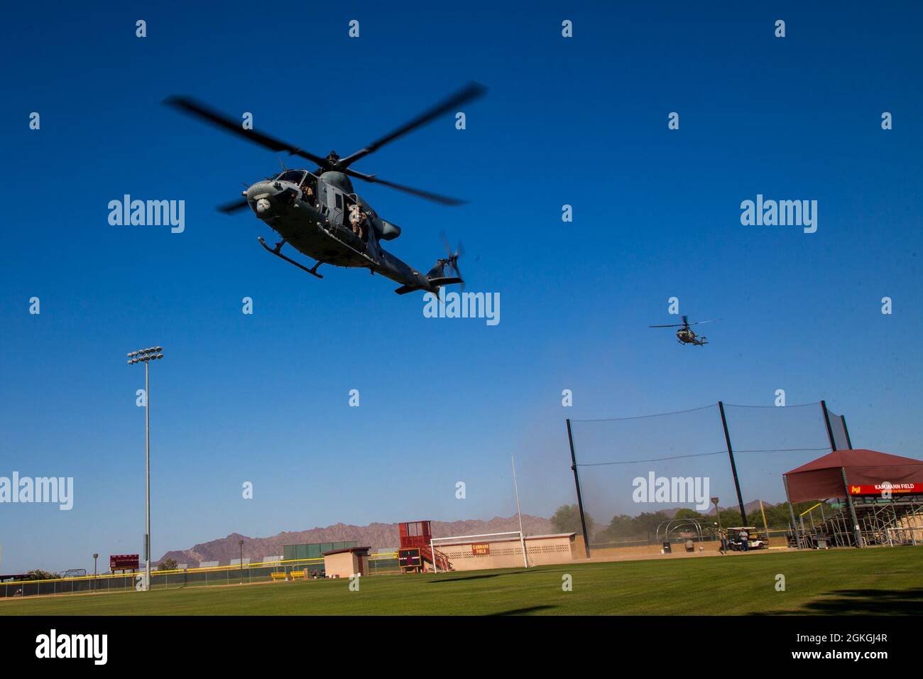 Venenos UH-1Y del Cuerpo de Infantería de Marina de los Estados Unidos, asignados al Escuadrón Uno de Armas y Tácticas de Aviación Marina (MAWTS-1), tierras durante las Tácticas de Apoyo a la Agresión 3 (AST-3), Ejercicio de Asistencia Humanitaria Extranjera, en apoyo al Curso de Instructor de Armas y Tácticas (WTI) 2-21, en el Arizona Western College, en Yuma, Arizona, Arizona, 16 de abril de 2021. WTI es un evento de capacitación de siete semanas organizado por MAWTS-1, que proporciona entrenamiento táctico avanzado estandarizado y certificación de las calificaciones de instructores de la unidad para apoyar el entrenamiento y preparación de la aviación marina, y ayuda en el desarrollo y empleo de armas y tácticas de aviación. Foto de stock