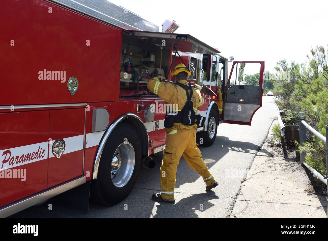 El bombero de rescate de incendios de San Diego saca equipo del motor durante un simulacro de incendio en Mission Trails Regional Park en Mission Gorge, San Diego. Foto de stock