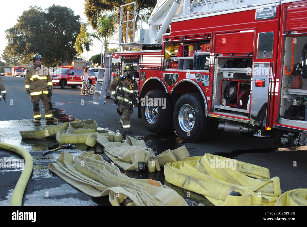 Los bomberos de San Diego Fire-Rescue recogen la manguera después de un incendio estructural en el vecindario de Bay Park en San Diego Foto de stock