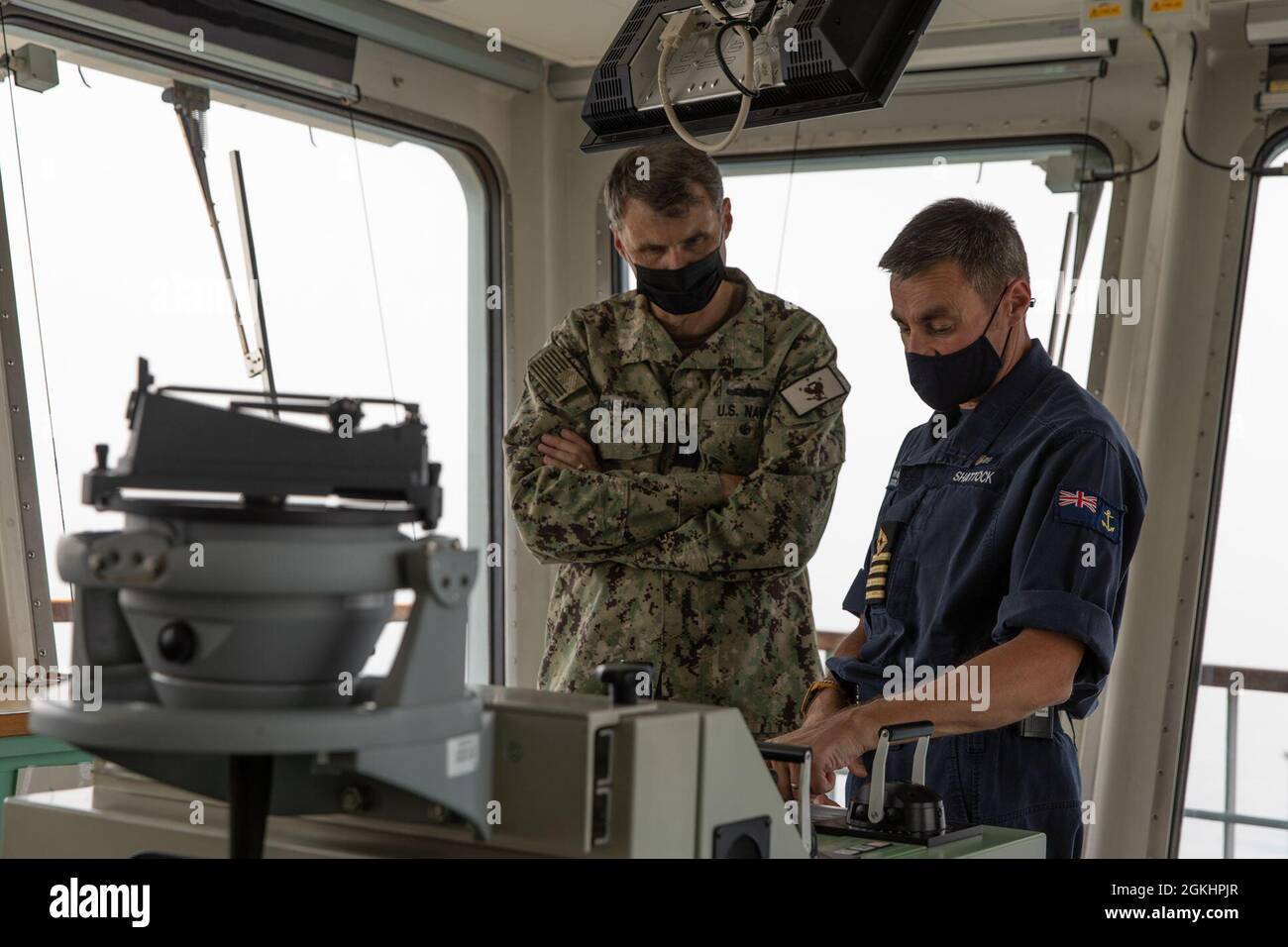210426-AUN662-1229 GOLFO ARÁBIGO (26 de abril de 2021) – Capt. Auxiliar de la flota real Sam Shattock, oficial al mando de Royal Fleet muelle del buque de desembarco auxiliar de la RFA Cardigan Bay (L 3009), der. y trasero ADM. Curt Renshaw, comandante adjunto del Comando Central de las Fuerzas Navales de los Estados Unidos y la Flota de los Estados Unidos 5th, habla sobre las capacidades de radar durante el ejercicio Artemis Trident 21 en el Golfo Arábigo, abril de 26. Artemis Trident 21 es un ejercicio multilateral de contramedidas contra las minas entre el Reino Unido, Australia, Francia y EE.UU., diseñado para mejorar la interoperabilidad mutua y las capacidades en la caza y remoción de minas, el secu marítimo Foto de stock