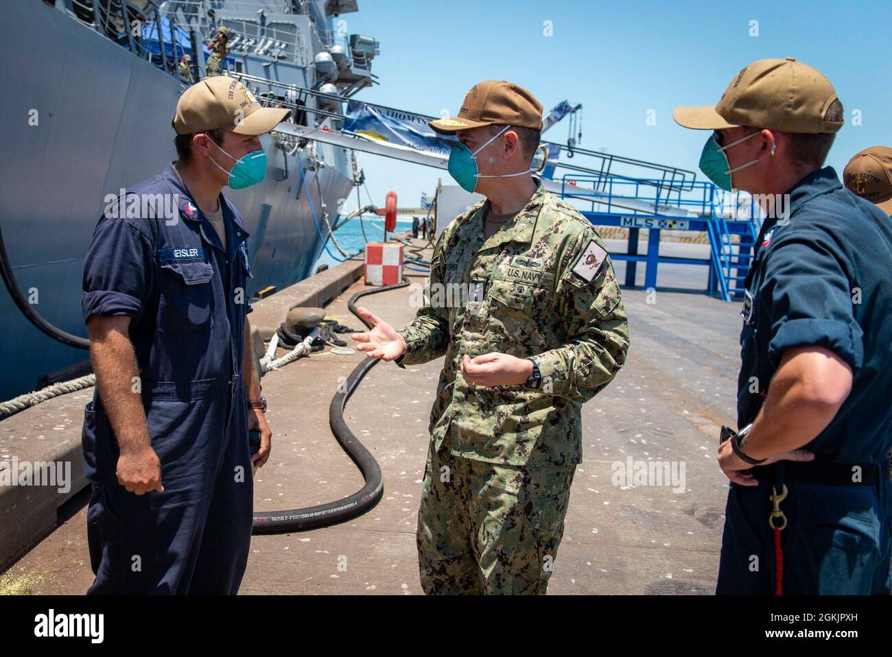 210506-N-VG727-1016 MANAMA, Bahrein (6 de mayo de 2021) Vice ADM. Brad Cooper, comandante del Comando Central de las Fuerzas Navales de los Estados Unidos (NAVCENT), la Flota de los Estados Unidos 5th y las Fuerzas Marítimas Combinadas (CMF), habla con Nicholas Geisler, de la Clase 1st de Boatswain, a la izquierda, Y Mate 2nd Class Dillon Sharer de Boatswain, asignado al destructor de misiles guiados USS Thomas Hudner de la clase Arleigh Burke (DDG 116), durante una llamada en el puerto en Manama, Bahrein, mayo de 6. Thomas Hudner está desplegado en el área de operaciones de la Flota de los Estados Unidos 5th y realizando operaciones navales para asegurar la estabilidad marítima y la seguridad en la Región Central, conectándose a TH Foto de stock