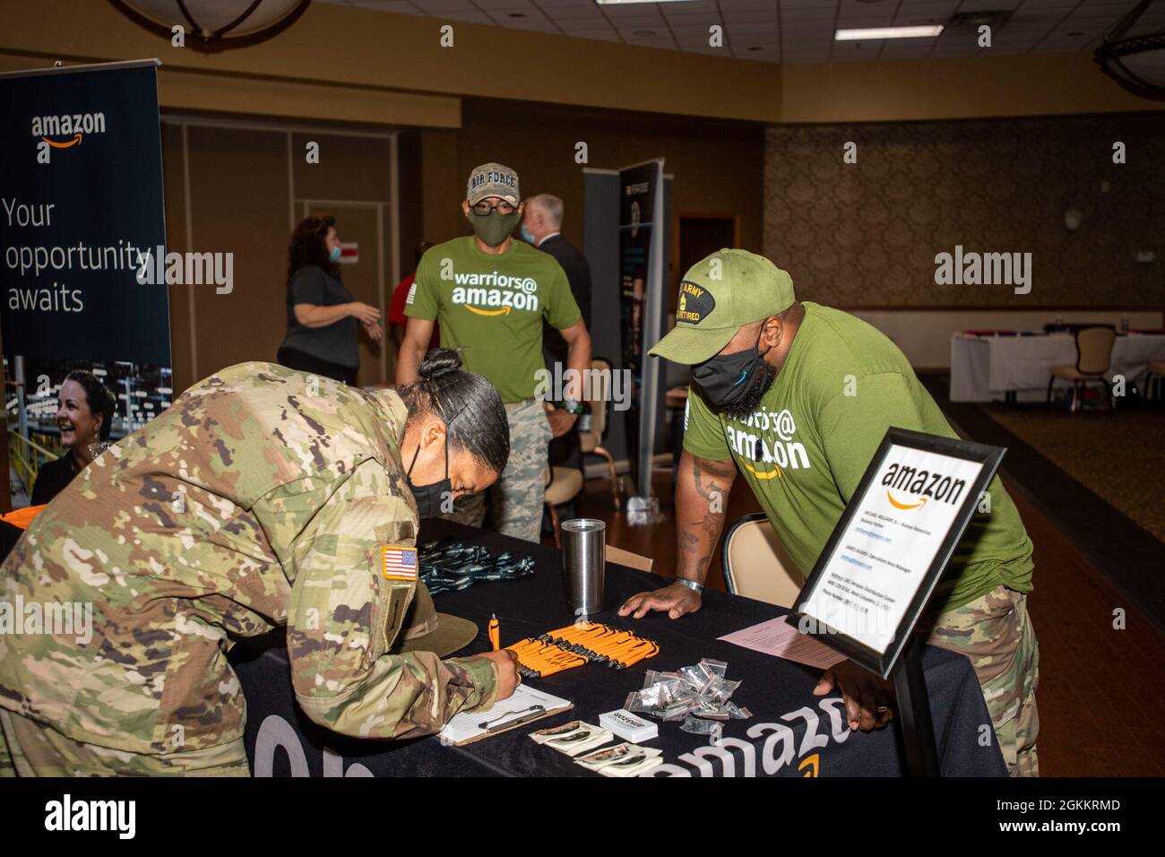 Un soldado habla con representantes de Amazon durante una feria de carrera en el NCO Club el 19 de mayo. Foto de stock