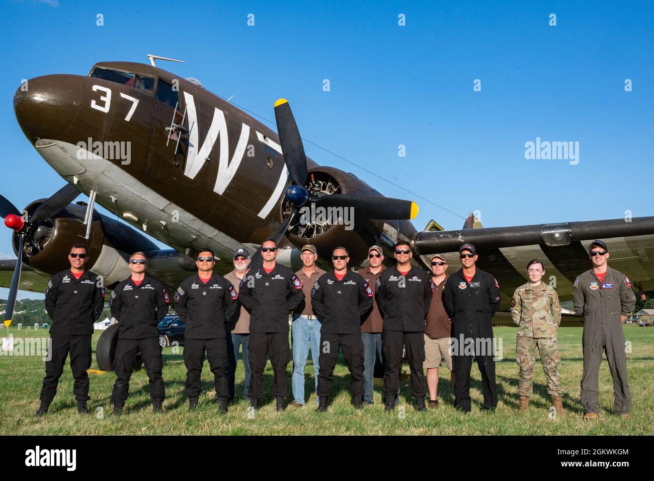 Los miembros del F-22 Demo Team posan para una foto con la tripulación de un C-47A, llamado Whisky 7, durante el Geneseo Airshow 10 de julio de 2021, Geneseo, N.Y. El equipo recibió un paseo en Whisky 7, y muchos expresaron lo humillante que era montar en un pedazo de historia de aviación militar. Foto de stock