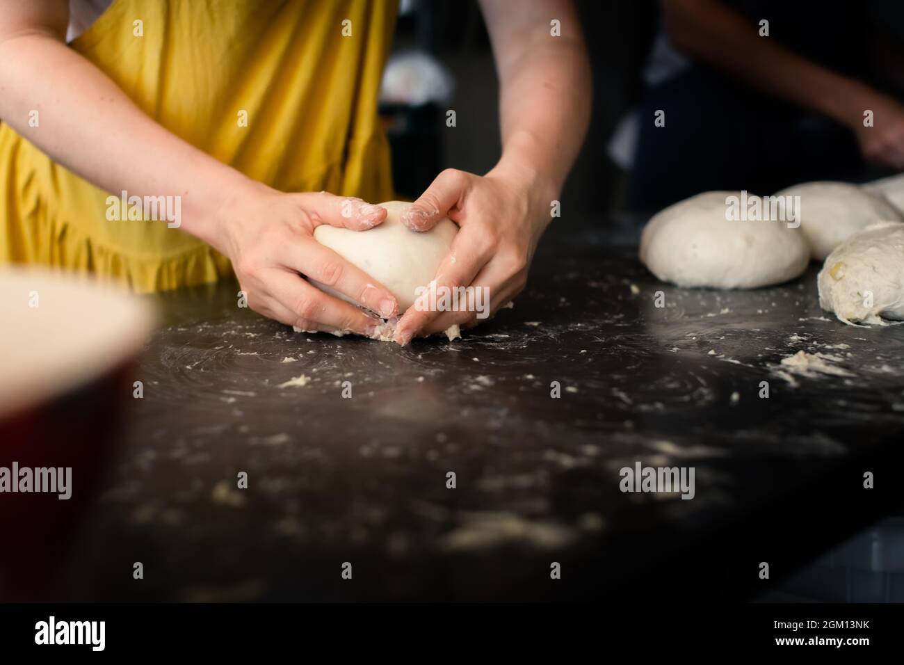 Mujer panadero forma pan en una mesa Foto de stock