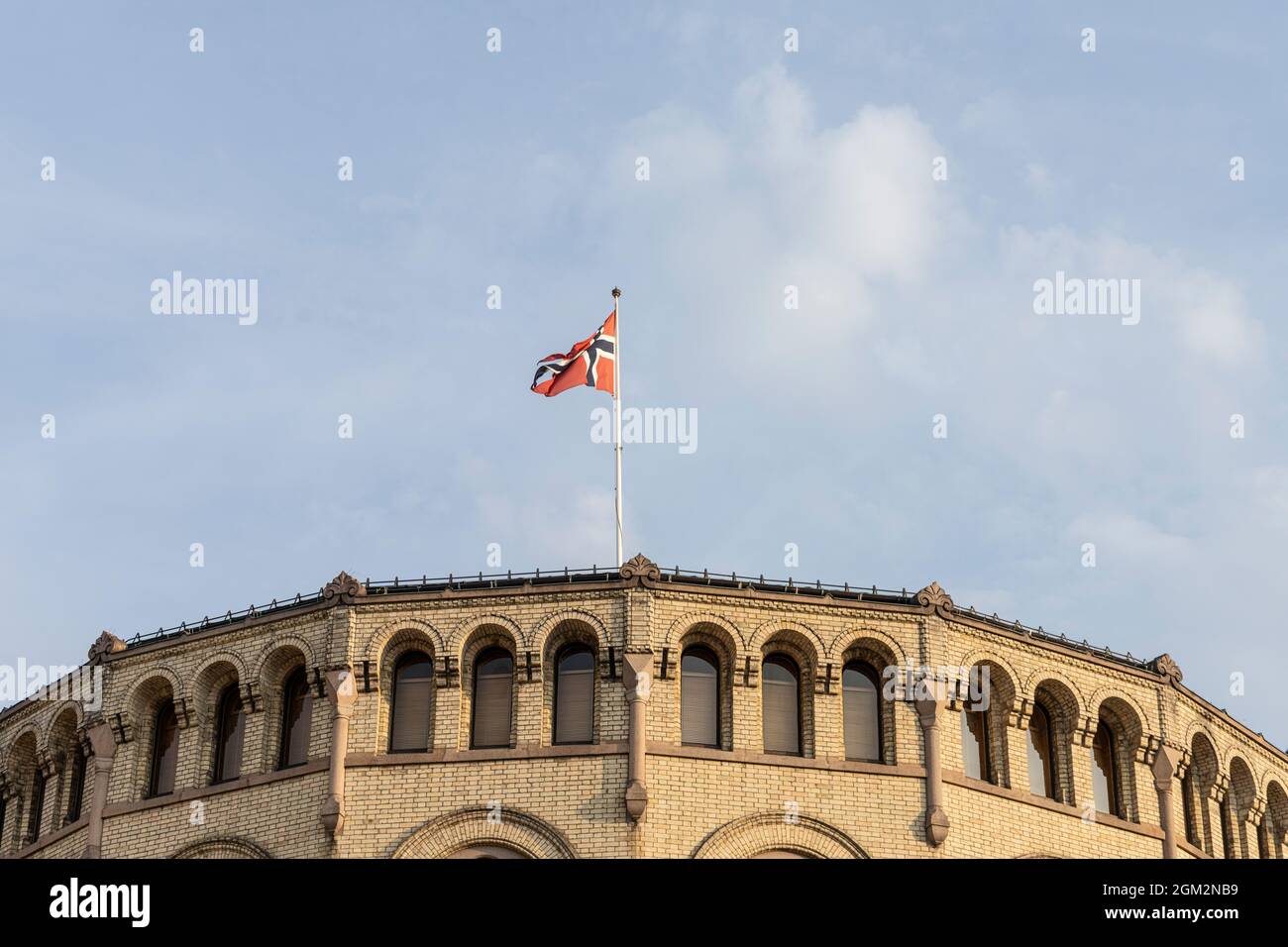 Oslo, Noruega. 2021 de septiembre: La bandera noruega se aletea en el techo del edificio del parlamento en el centro de la ciudad Foto de stock