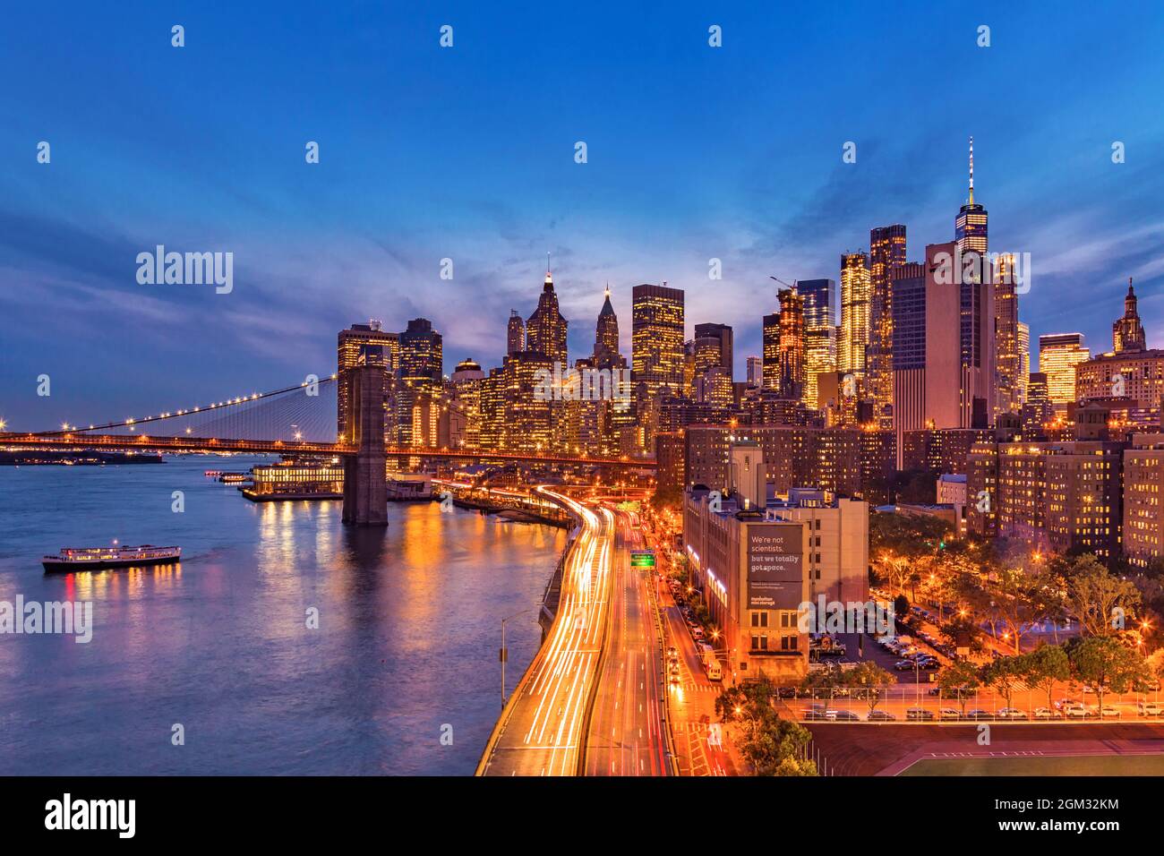 Puente de Brooklyn y Manhattan - vistas al Puente de Brooklyn, la autopista FDR y el distrito financiero durante la hora azul. Foto de stock