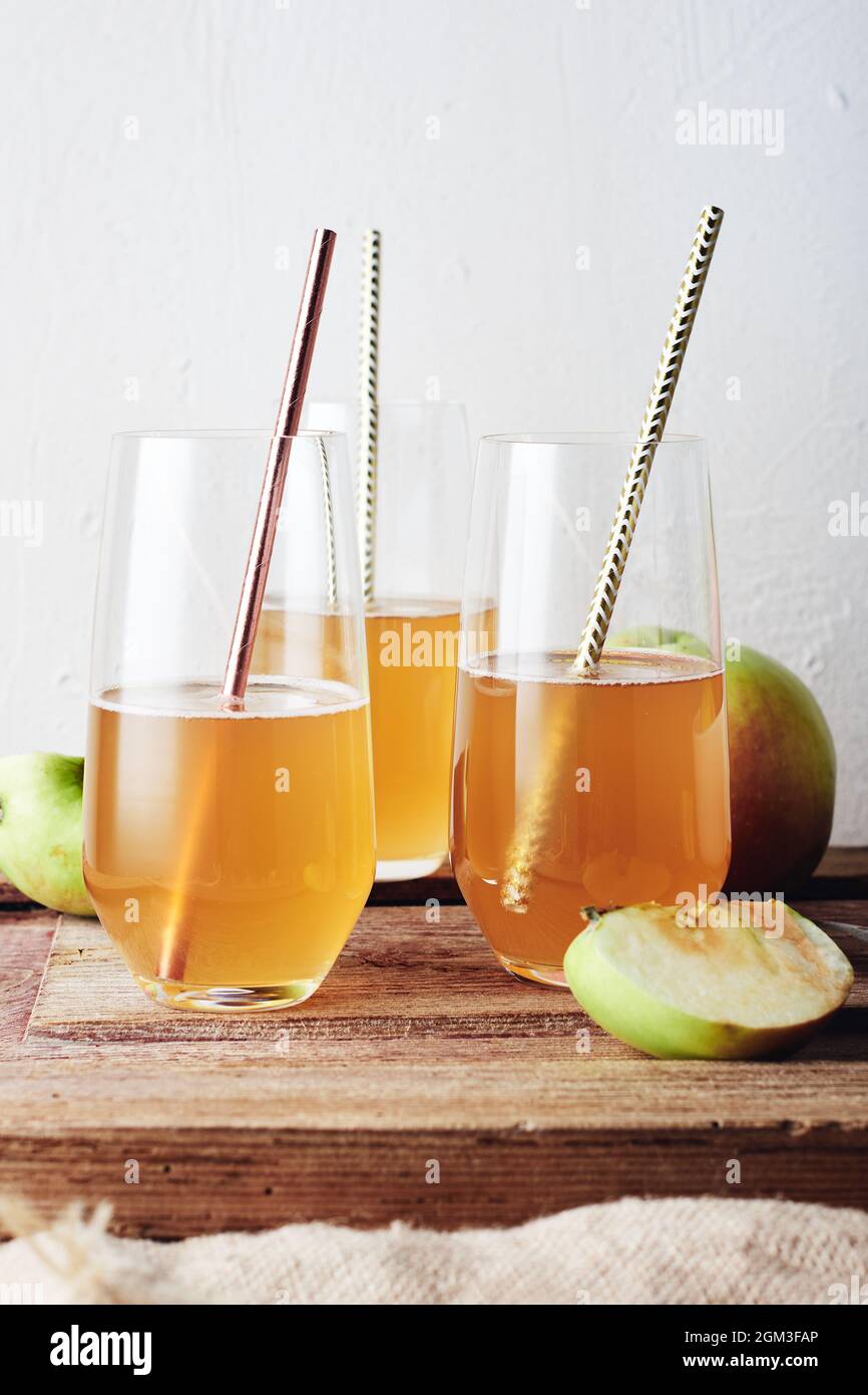 Tres vasos de manzana, sidra sobre una mesa de madera. Foto de stock