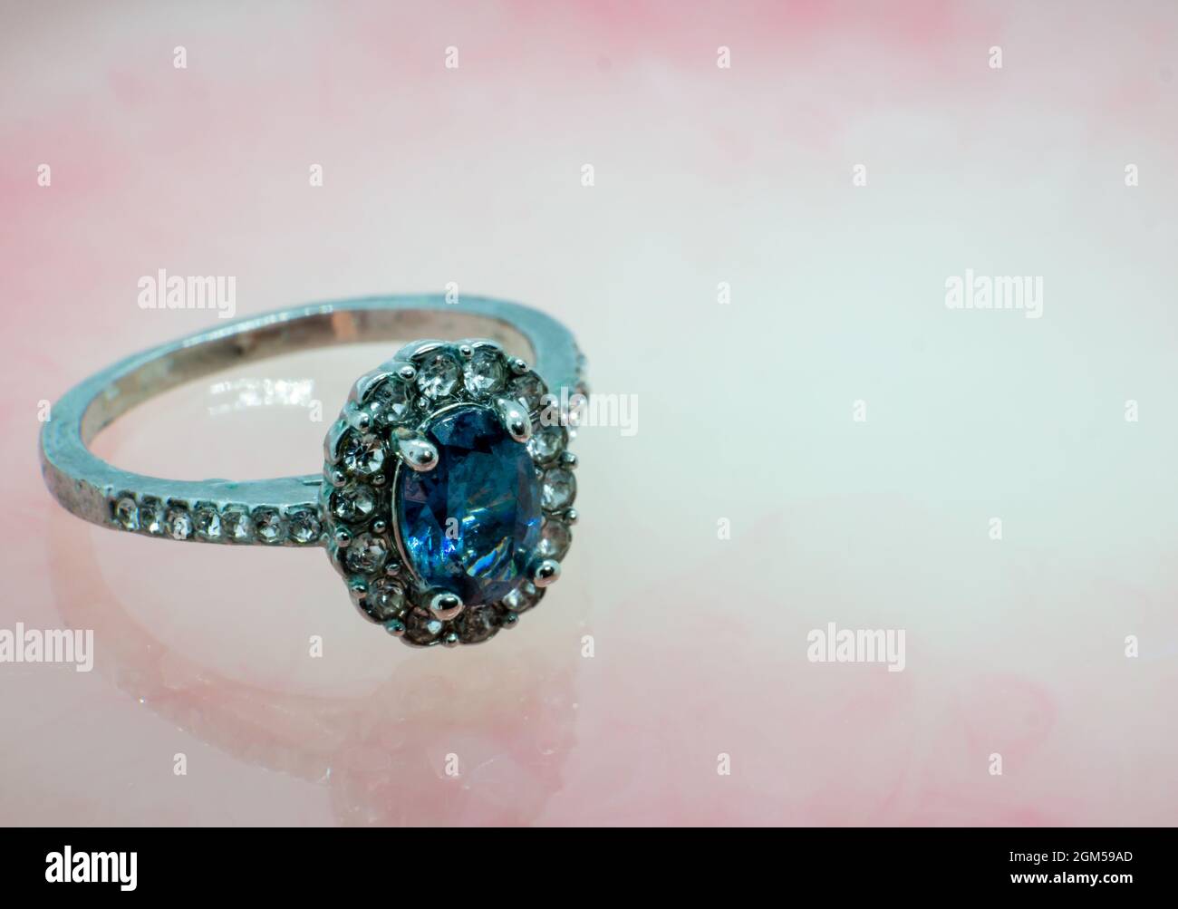 anillo con piedra preciosa, conjunto de gemas de zafiro. fondo de mármol rosa Foto de stock