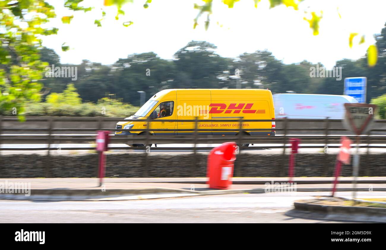 Una camioneta DHL conduciendo por el M27near Southampton hacia fuera en entregas rodadas como un barrido de tiro con movimiento. Foto de stock