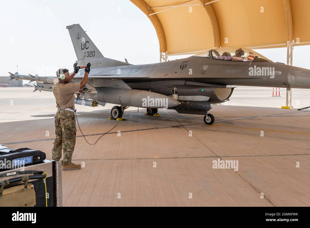 Un jefe de la tripulación de la Fuerza Aérea de los Estados Unidos con el Escuadrón de la Generación de Cazas Expedicionarias 121st dirige un F-16 Fighting Falcon durante el prelanzamiento en la Base Aérea del Príncipe Sultán, Reino de Arabia Saudita, el 27 de agosto de 2021. Además del apoyo logístico y de la mano de obra, el Ala Expedicionaria Aérea de 378th proporcionó energía aérea de combate para asegurar la superioridad aérea del Comando Central de Estados Unidos durante las operaciones de evacuación no combatiente en Afganistán. (EE.UU Foto de la Fuerza Aérea del personal Sgt. Caleb Pavao) Foto de stock