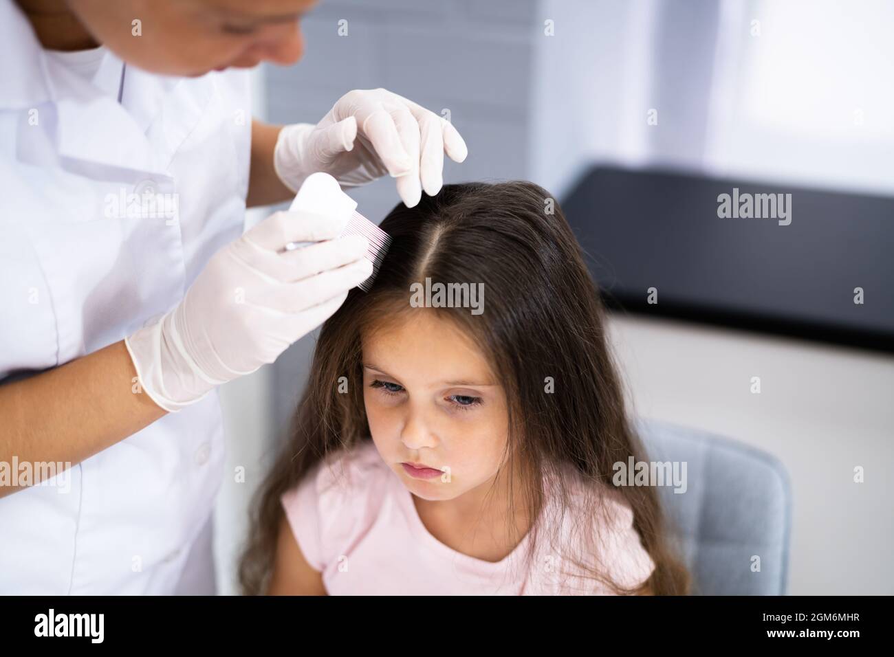 Niño Doctor que revisa el cabello de la cabeza para Lice Foto de stock