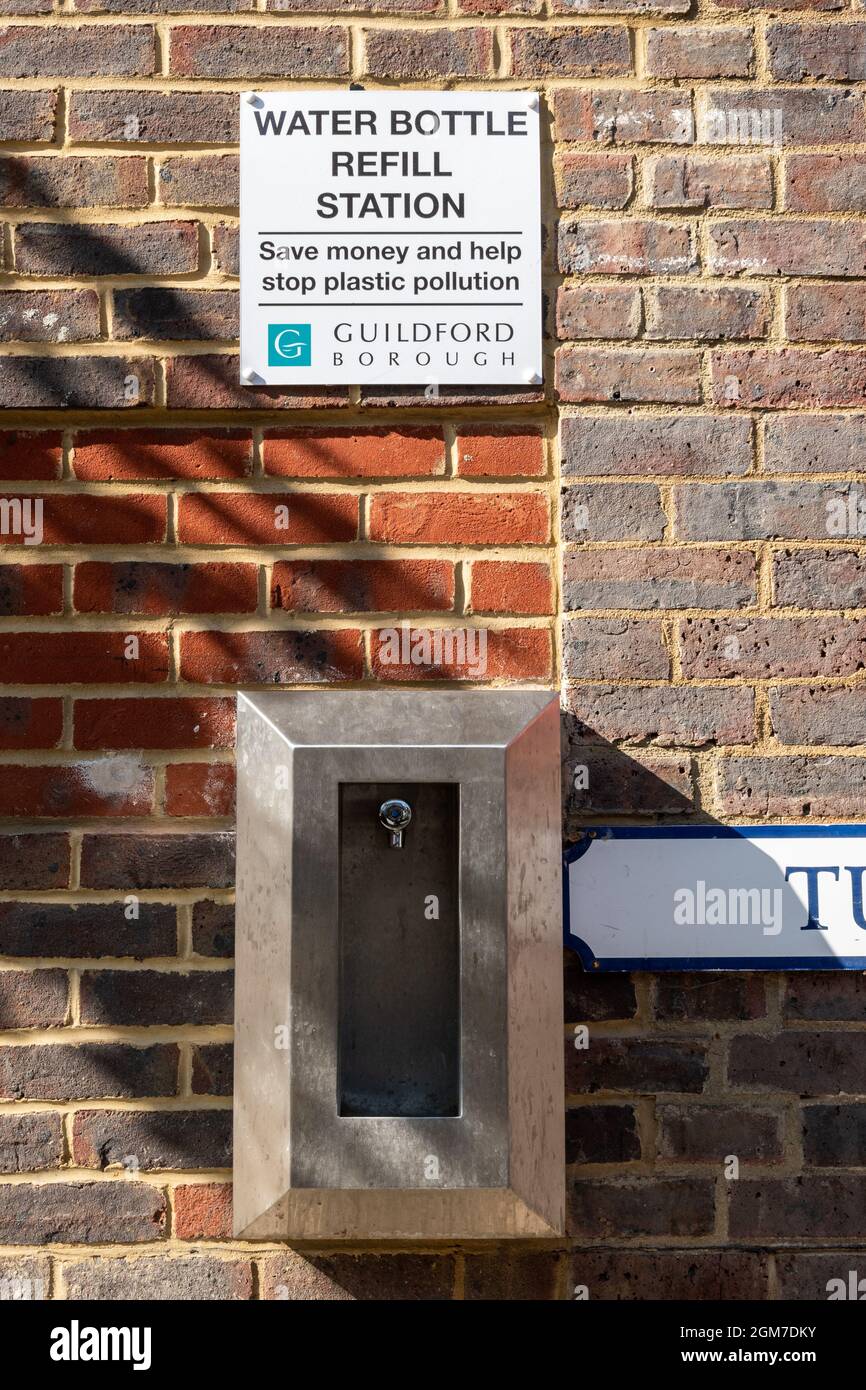 Estación de recarga de botellas de agua en el centro de la ciudad de Guildford, el letrero dice Ahorre dinero y ayude a detener la contaminación plástica Foto de stock