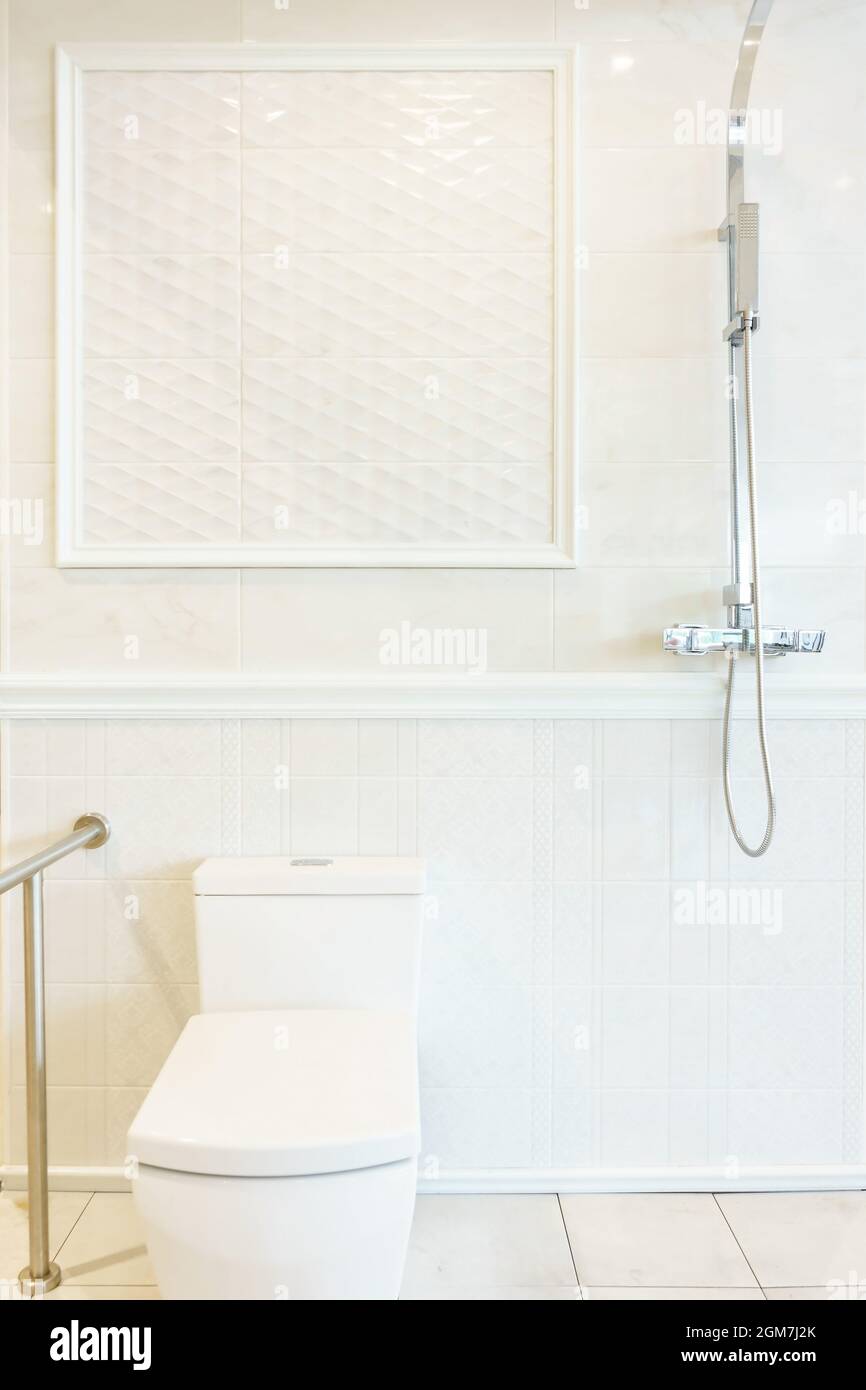 Cuarto de baño interior con ducha, calentador de agua e inodoro en la pared  de azulejos blancos Fotografía de stock - Alamy