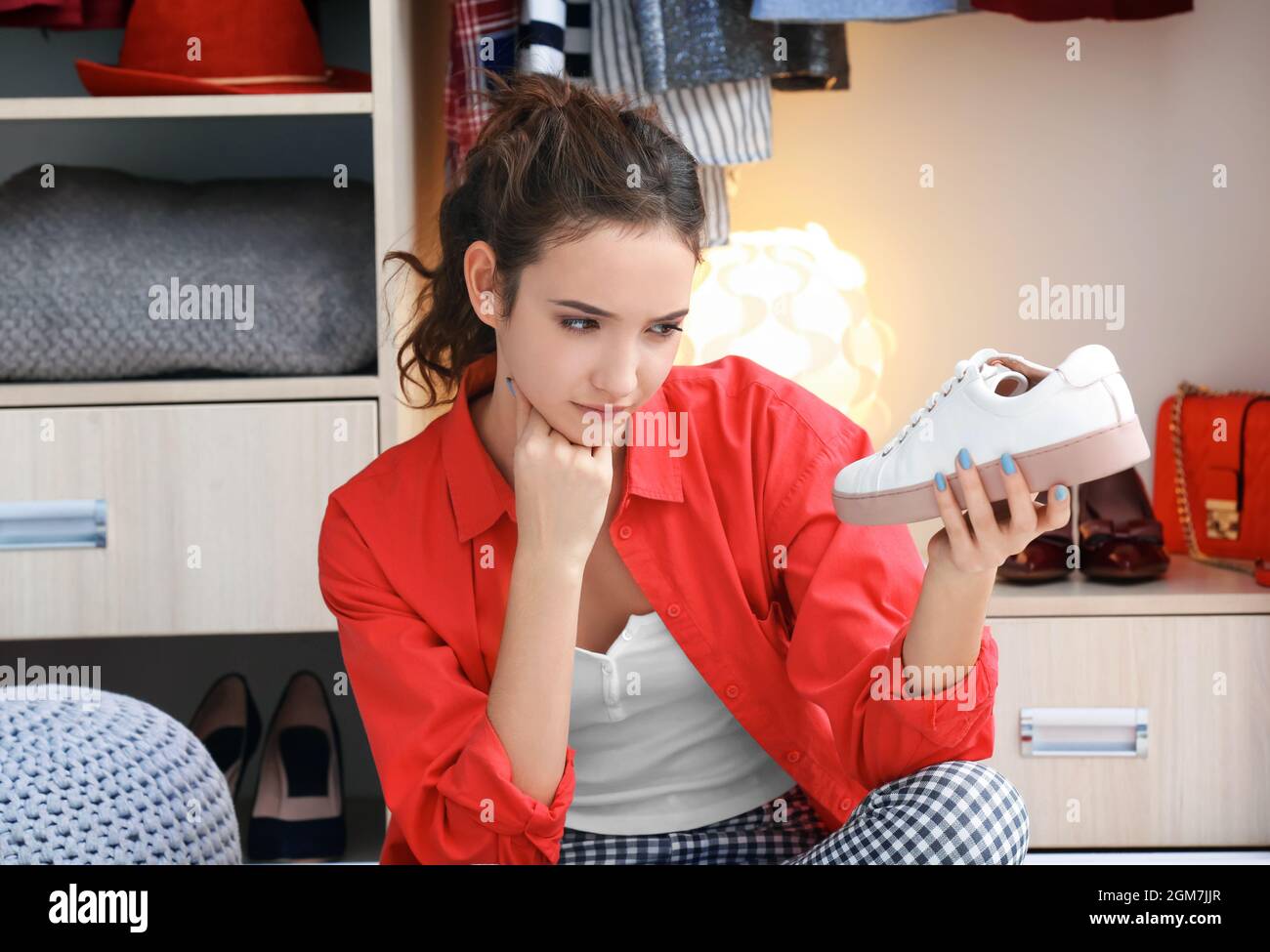 Hermosa chica escogiendo zapatos cerca del armario en casa Fotografía de  stock - Alamy