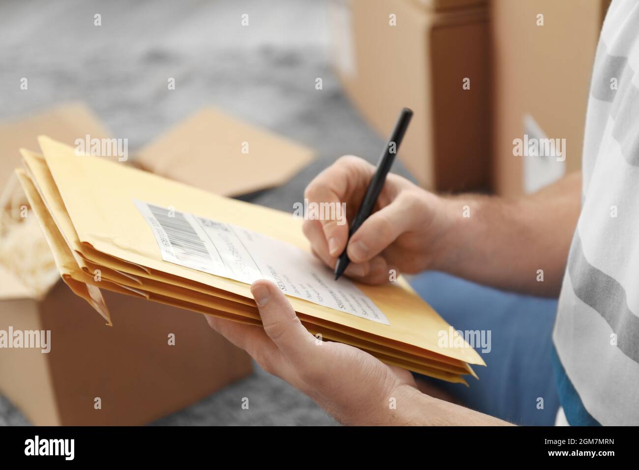 Hombre joven preparando sobres de paquetes para su envío al cliente en  casa, closeup Fotografía de stock - Alamy