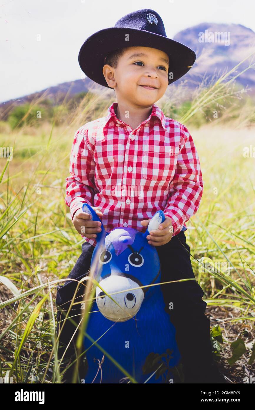 Niño blanco vestido como un vaquero, jugando en el bosque con su caballo de  juguete. Retrato infantil para el día de los niños, moda infantil, moda  rural Fotografía de stock - Alamy