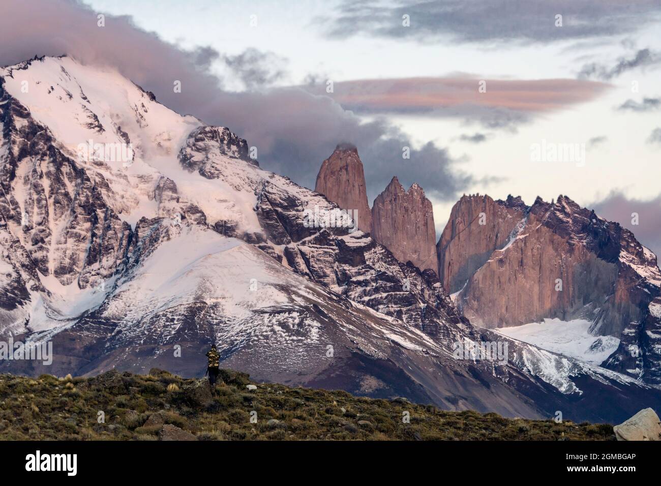 Pequeña figura de fotógrafo que captura el amanecer en Torres del Paine, Patagonia Foto de stock