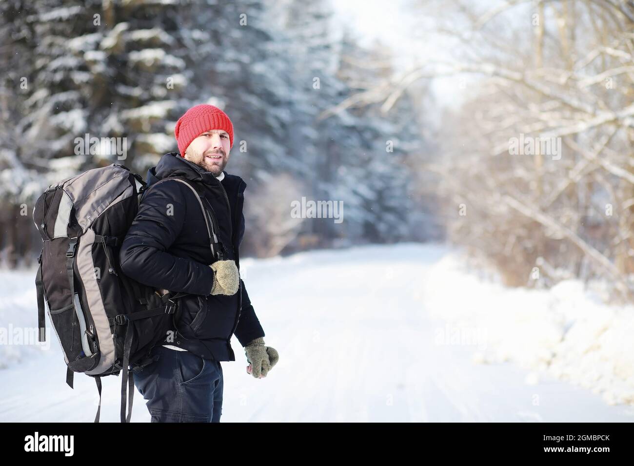 Un hombre viaja con una mochila. Caminata de invierno en el bosque. Turista  en un paseo en el invierno en un parque Fotografía de stock - Alamy