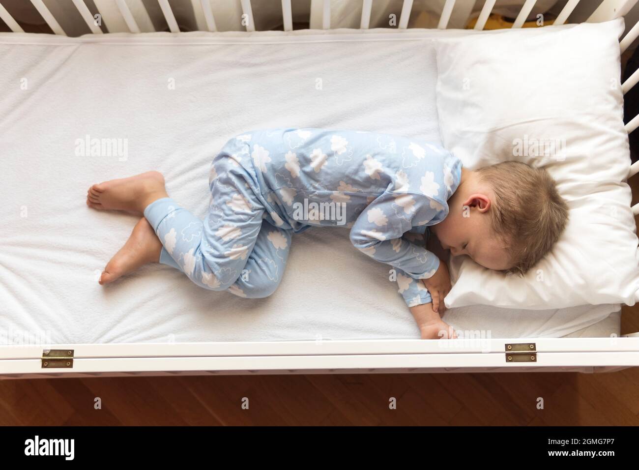 Vista superior Cute Pequeño 2-3 años preescolar niño niño niño durmiendo  dulcemente en cuna blanca durante el almuerzo tiempo de descanso en pijama  azul con almohada en casa Fotografía de stock - Alamy