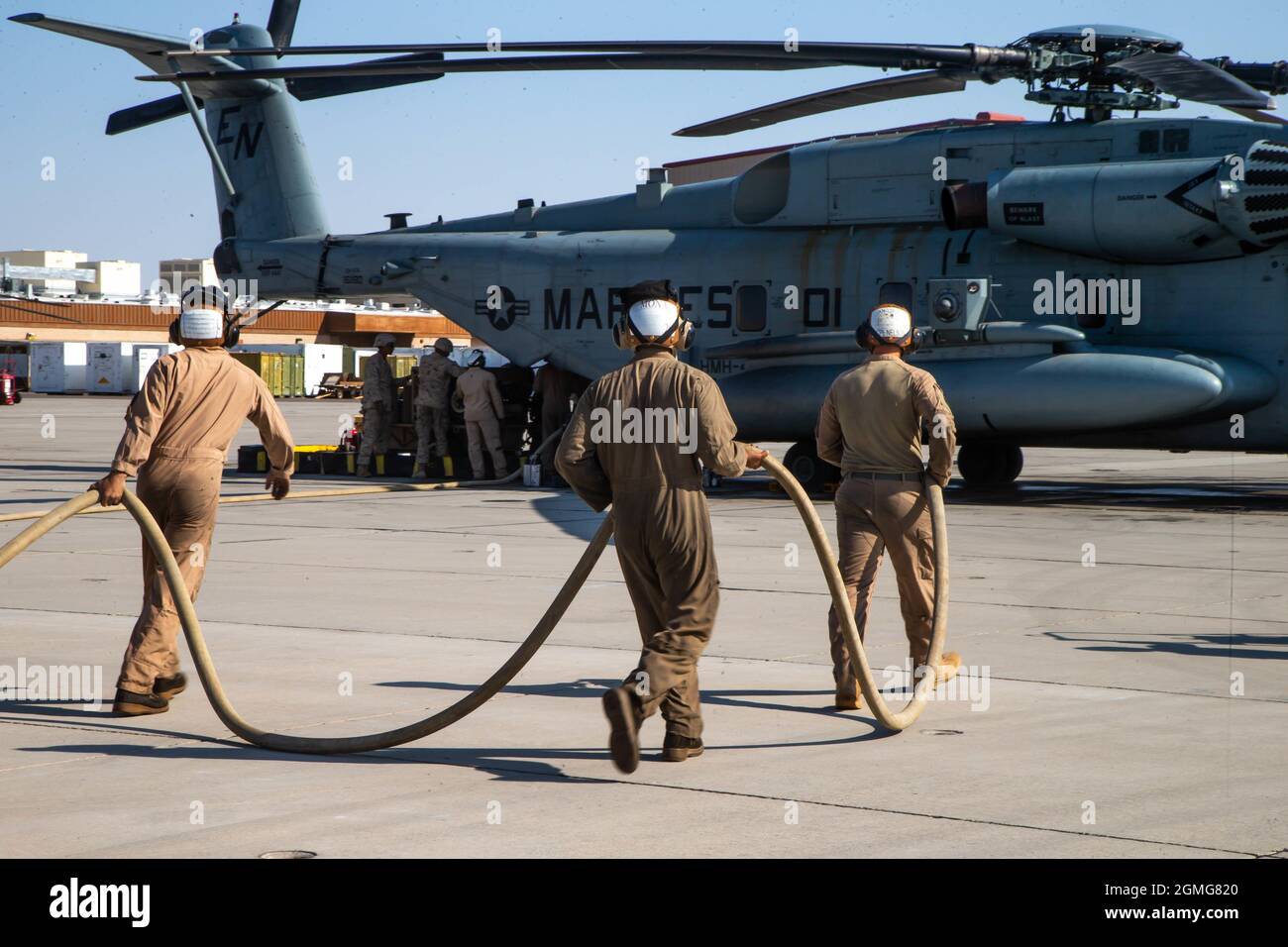 Los especialistas en combustible a granel del Cuerpo de Marines de los Estados Unidos, asignados al Escuadrón Uno de Armas y Tácticas de Aviación Marina (MAWTS-1), transportan una manguera de combustible durante una demostración de repostaje en tierra entregada por aire en apoyo del curso de Instructor de Armas y Tácticas (WTI) 1-22, en la Estación Aérea del Cuerpo de Marina Yuma, Arizona, el 16 de septiembre de 2021. WTI es un evento de capacitación de siete semanas organizado por MAWTS-1, que proporciona entrenamiento táctico avanzado estandarizado y certificación de las calificaciones de instructores de la unidad para apoyar el entrenamiento y preparación de la aviación marina, y ayuda en el desarrollo y empleo de armas y tácticas de aviación. (EE.UU Mar Foto de stock