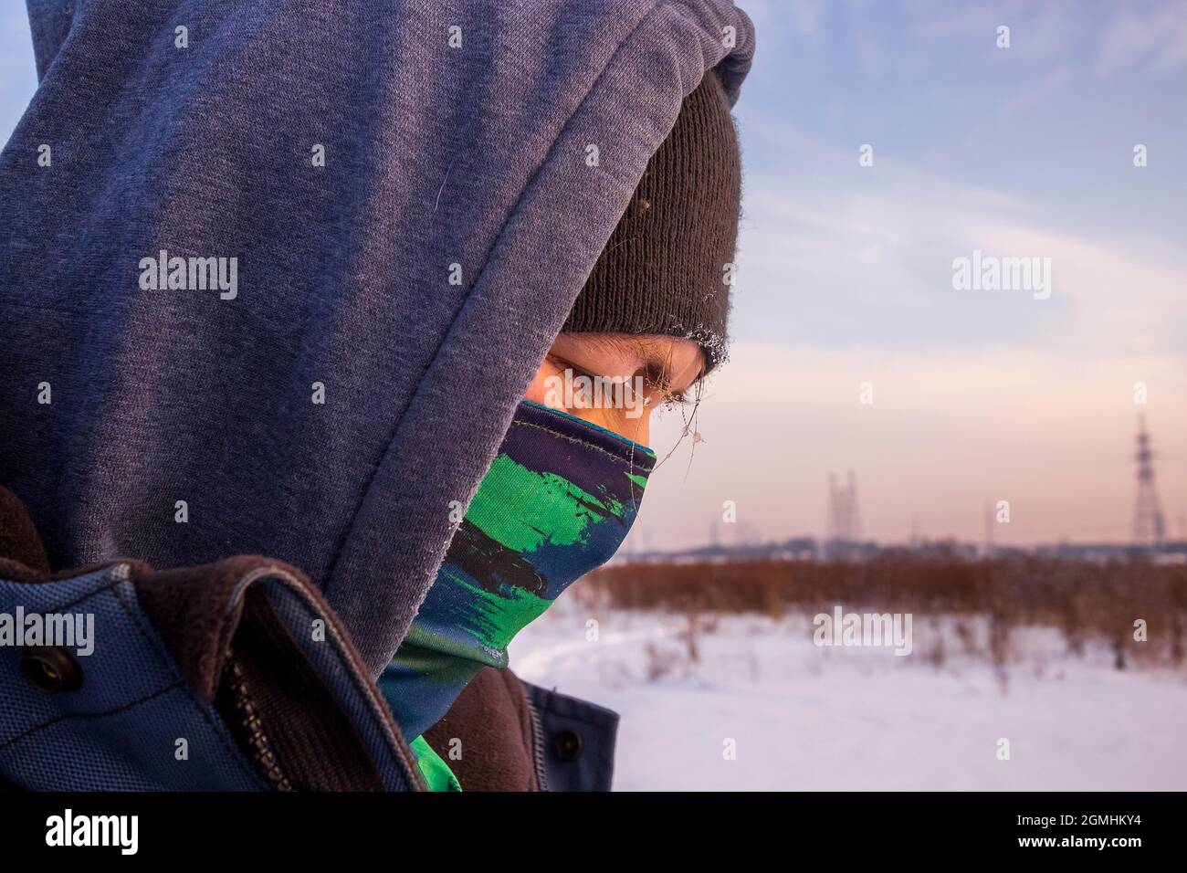 Vista de cerca de una cara de hombre caucásico con bufanda como máscara y  chaqueta de invierno con capucha Fotografía de stock - Alamy
