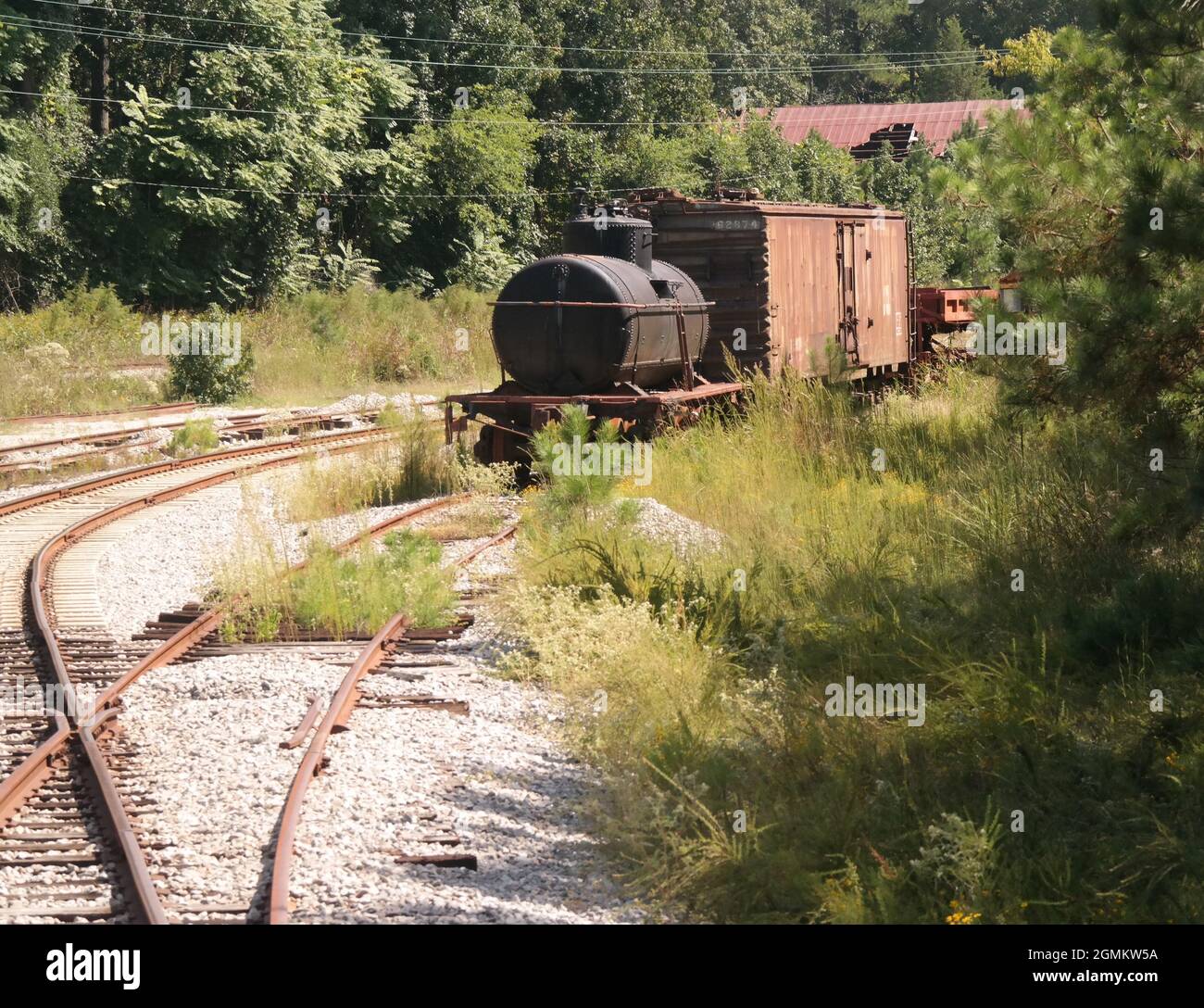 Viejos coches de tren abandonados oxidados en el revestimiento de la vía Foto de stock