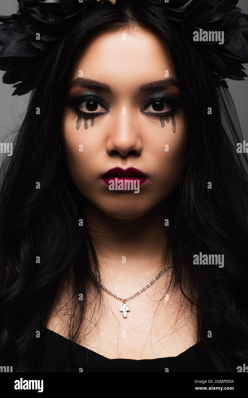 mujer asiática morena con vampiro halloween maquillaje mirando la cámara  aislada en gris Fotografía de stock - Alamy