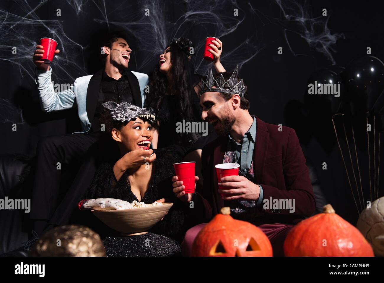 amigos multiétnicos en disfraces de halloween hablando mientras se comen palomitas de maíz y se bebe cerveza en negro Fotografía de stock - Alamy amigos multiétnicos en disfraces de halloween hablando mientras se comen palomitas de maíz y se bebe cerveza en negro Fotografía de stock - Alamy