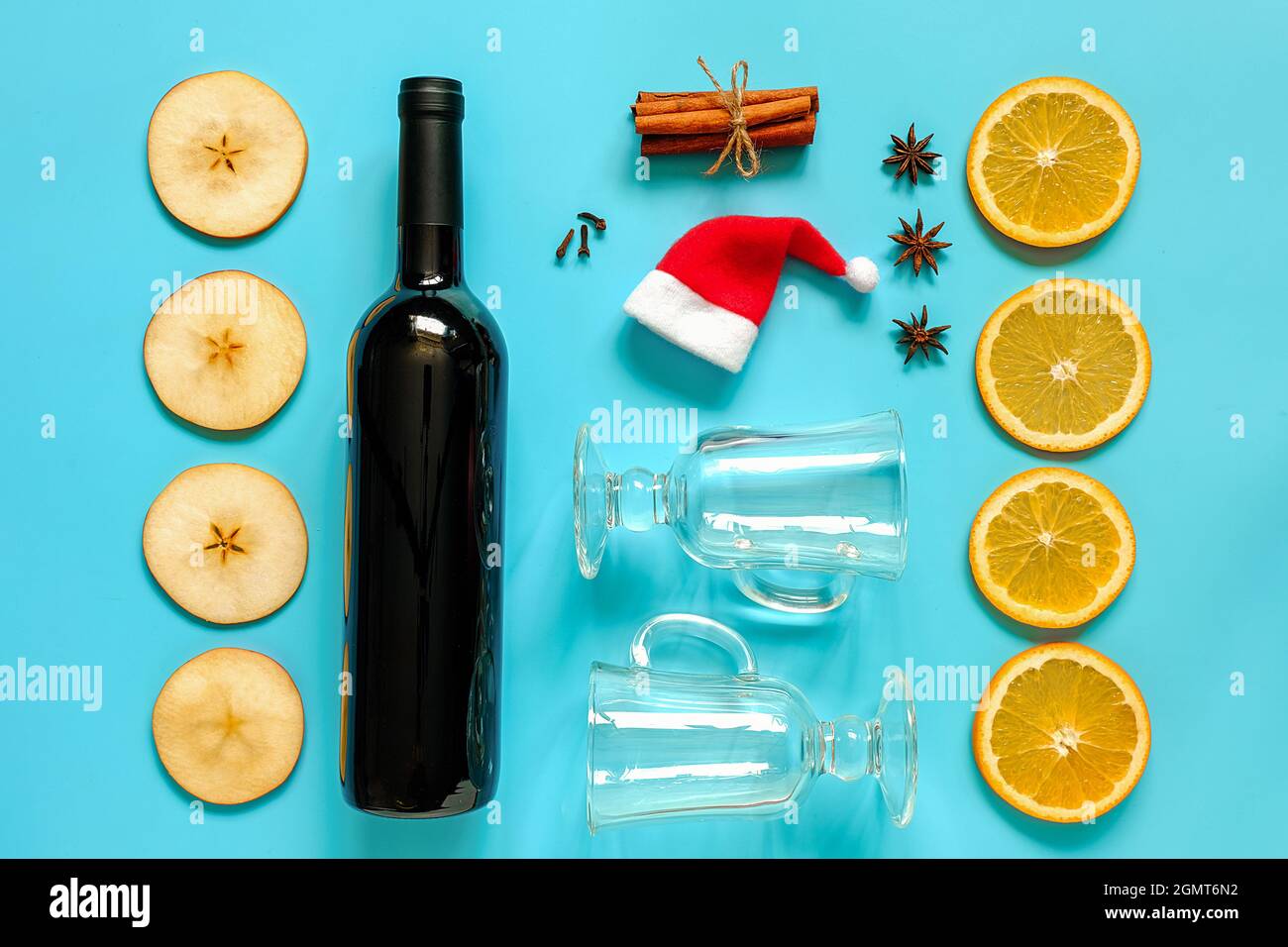 Ingredientes de vino caliente, vida en el fondo azul. Botella de vino,  bastones de canela, rodajas de naranja, manzana, anís y taza. Concepto  culinario recii Fotografía de stock - Alamy