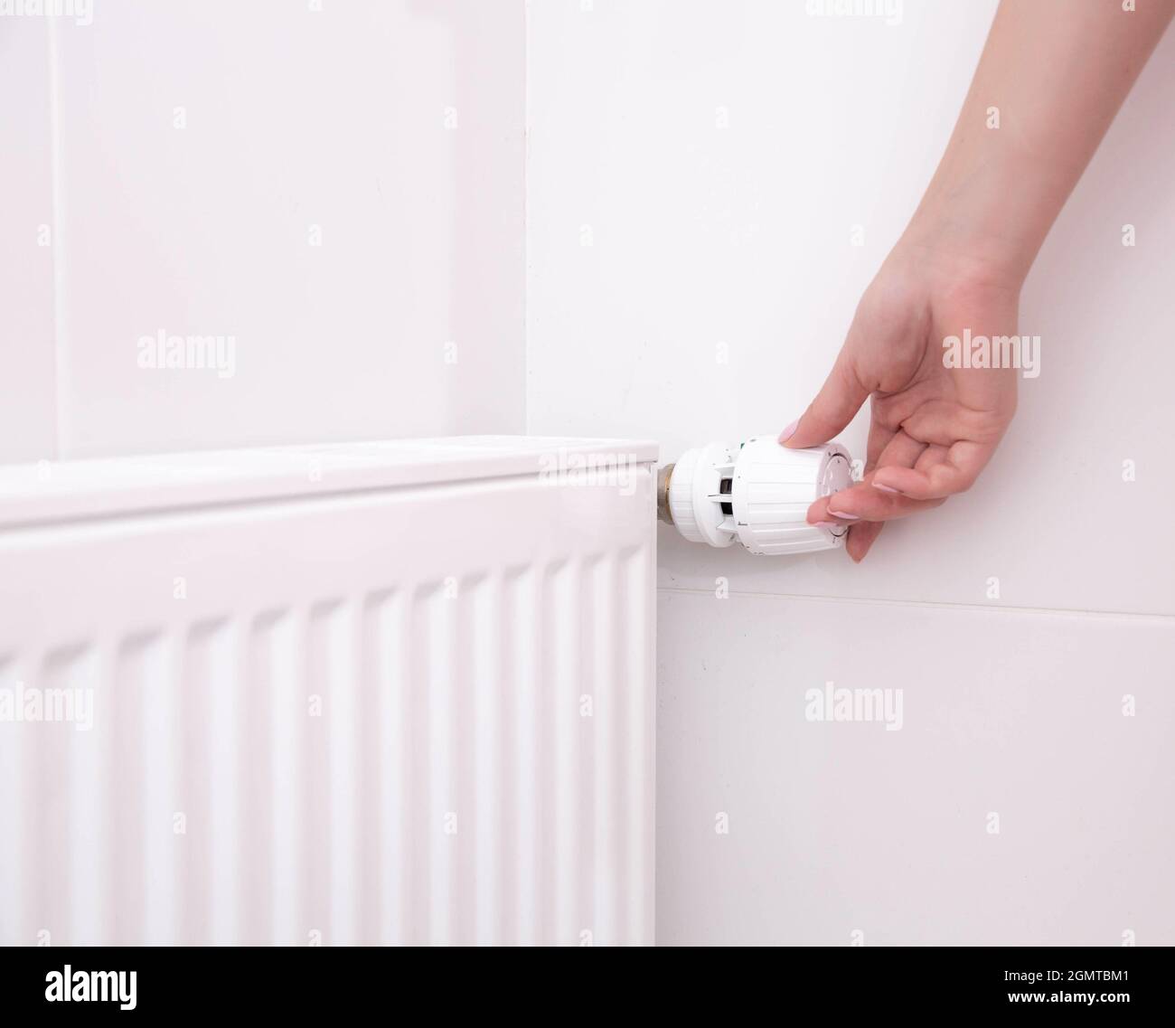 Una mano de mujer sostiene el mango del termostato de calefacción. Concepto  de coste del servicio de calefacción, aumento de precio de la utilidad  Fotografía de stock - Alamy