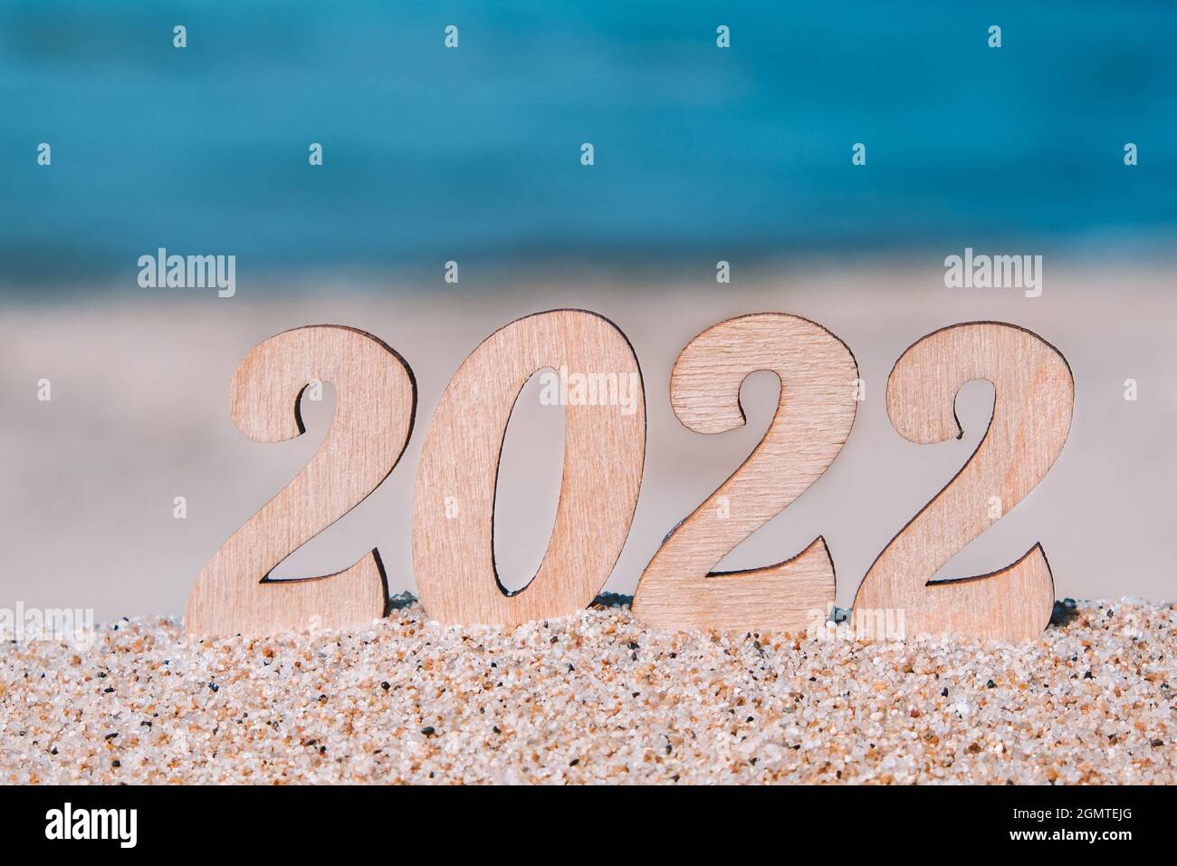 Número de Año Nuevo 2022 en la playa junto al mar. Concepto de turismo, recreación y viajes. Postal navideña creativa. Espacio de copia. Enfoque selectivo. Foto de stock