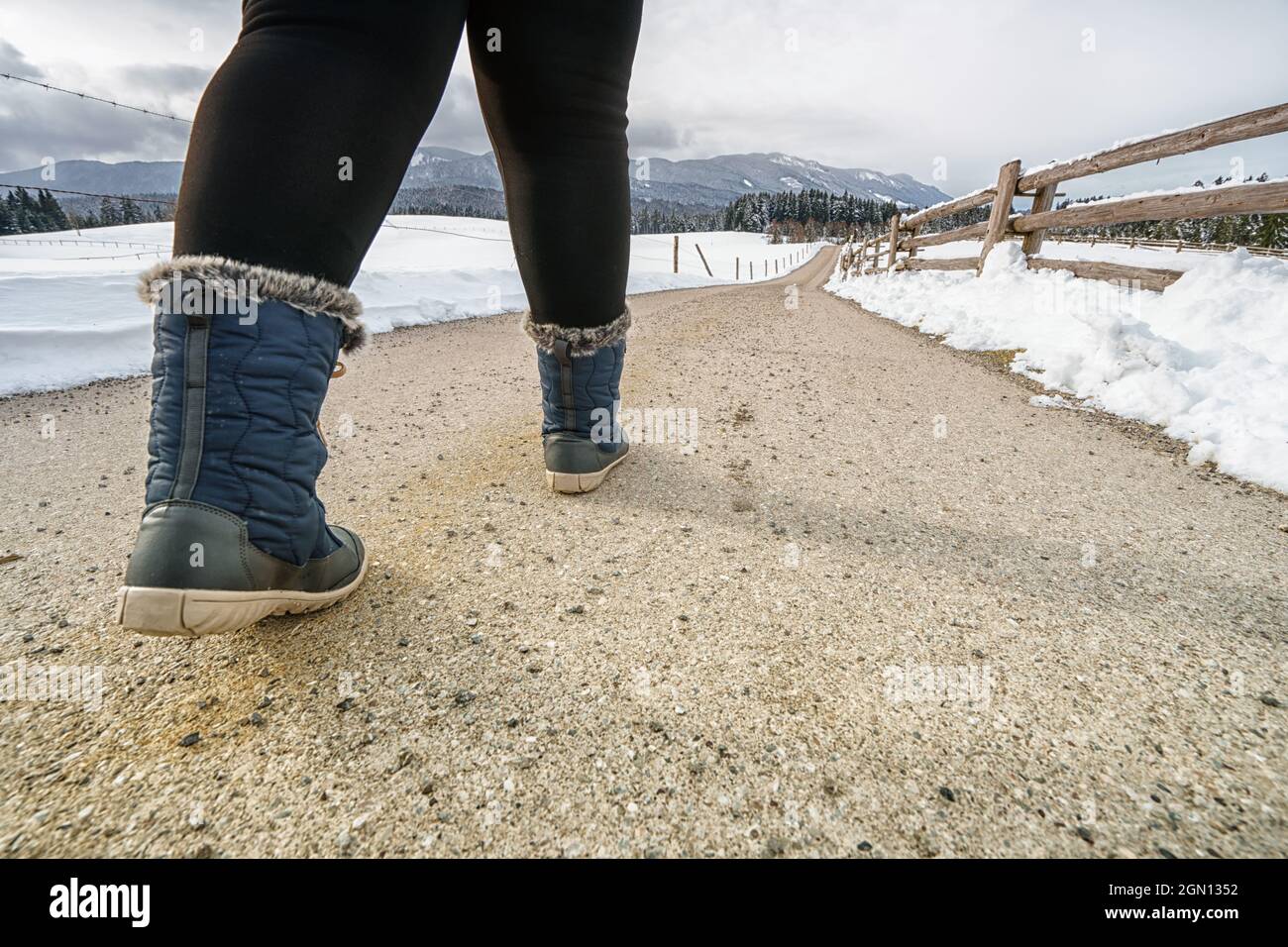 en botas de invierno azul cálido caminando en una carretera de campo en un día de invierno en el Tirol, Austria Fotografía de stock - Alamy