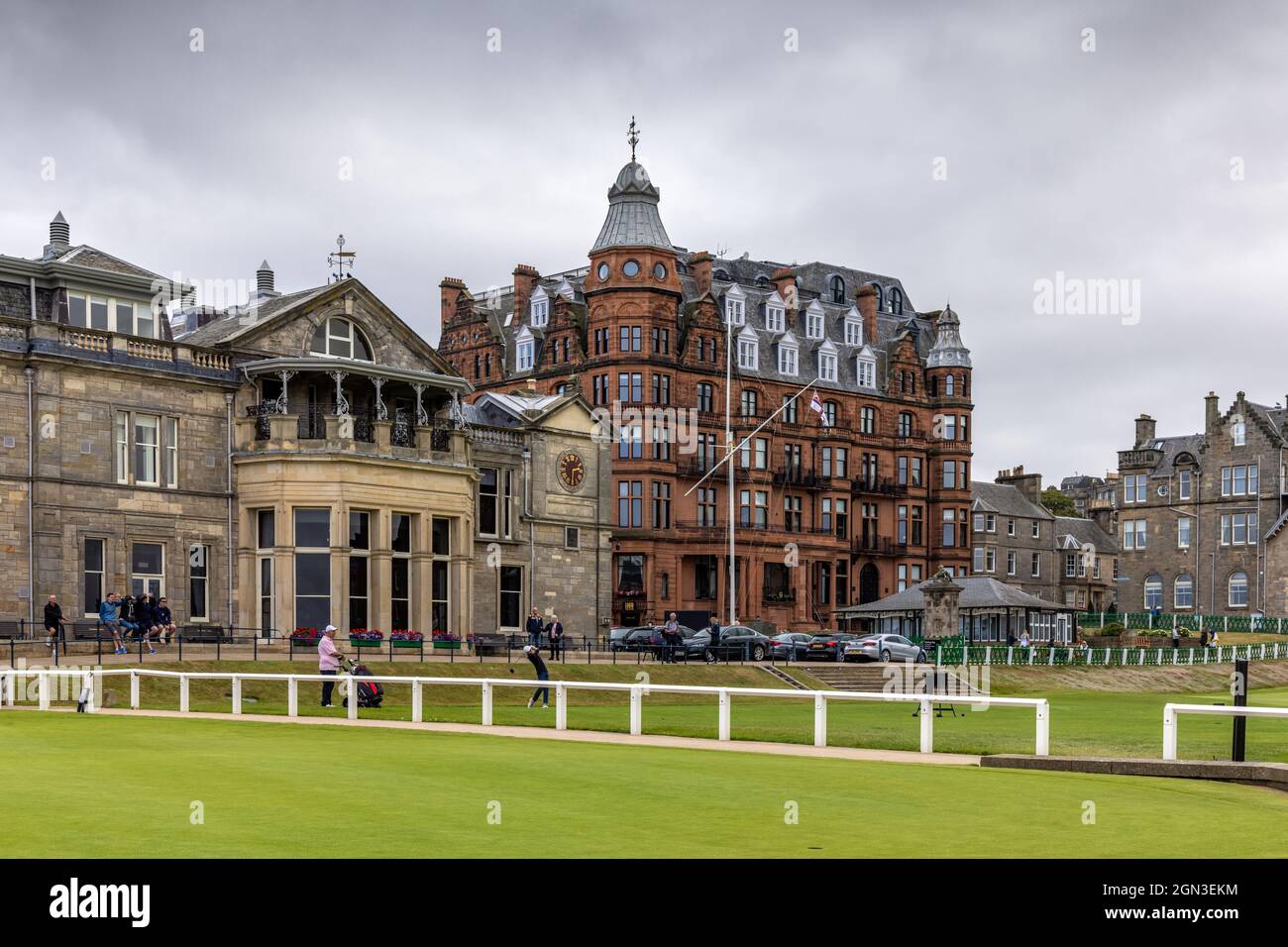 Juegue en el Royal and Ancient Golf Club de St Andrews en Fife, con el Hamilton Grand (Old Course Hotel) de arenisca roja al fondo. Foto de stock