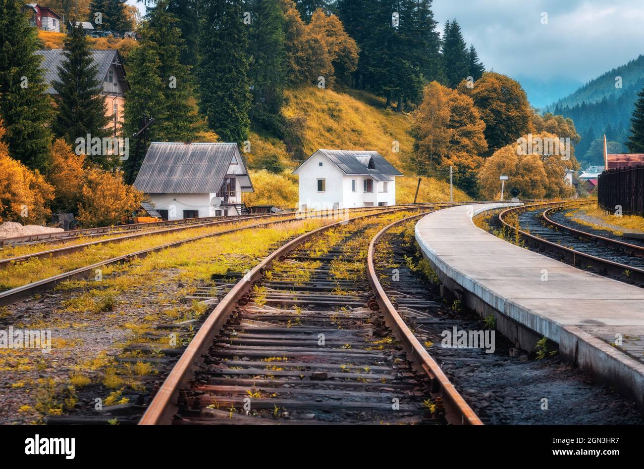 Estación de tren y casa blanca en el pueblo de montaña al atardecer Foto de stock
