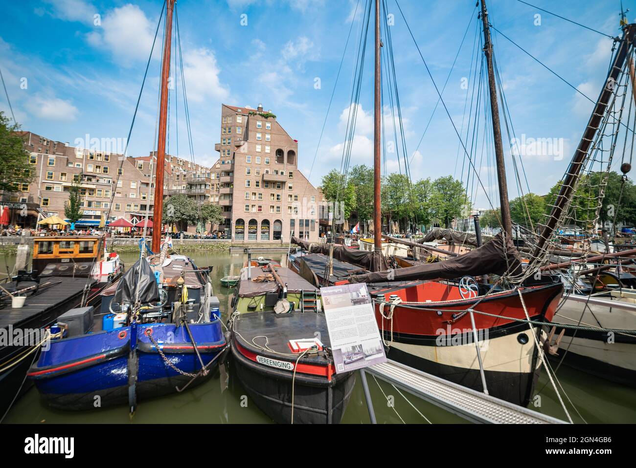 Rotterdam Holanda - Agosto 22 2021; Embarcaciones de vela históricas  amarradas a lo largo del muelle en la zona del puerto antiguo de la ciudad  con edificios de apartamentos en el fondo