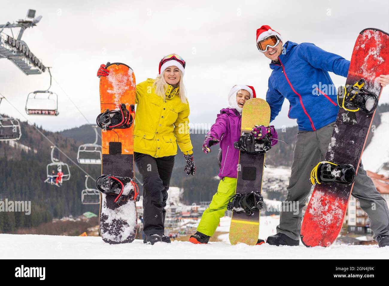 Retrato de familia feliz en Santa Gorras y snowboard en el resort de  invierno Fotografía de stock - Alamy