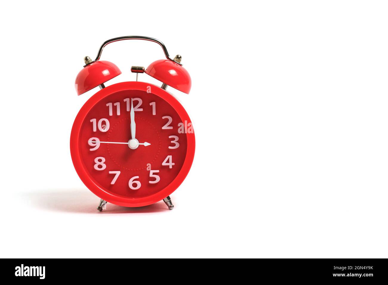 El reloj de alarma rojo está aislado sobre un fondo blanco, muestra doce  horas de reloj, noche y almuerzo Fotografía de stock - Alamy