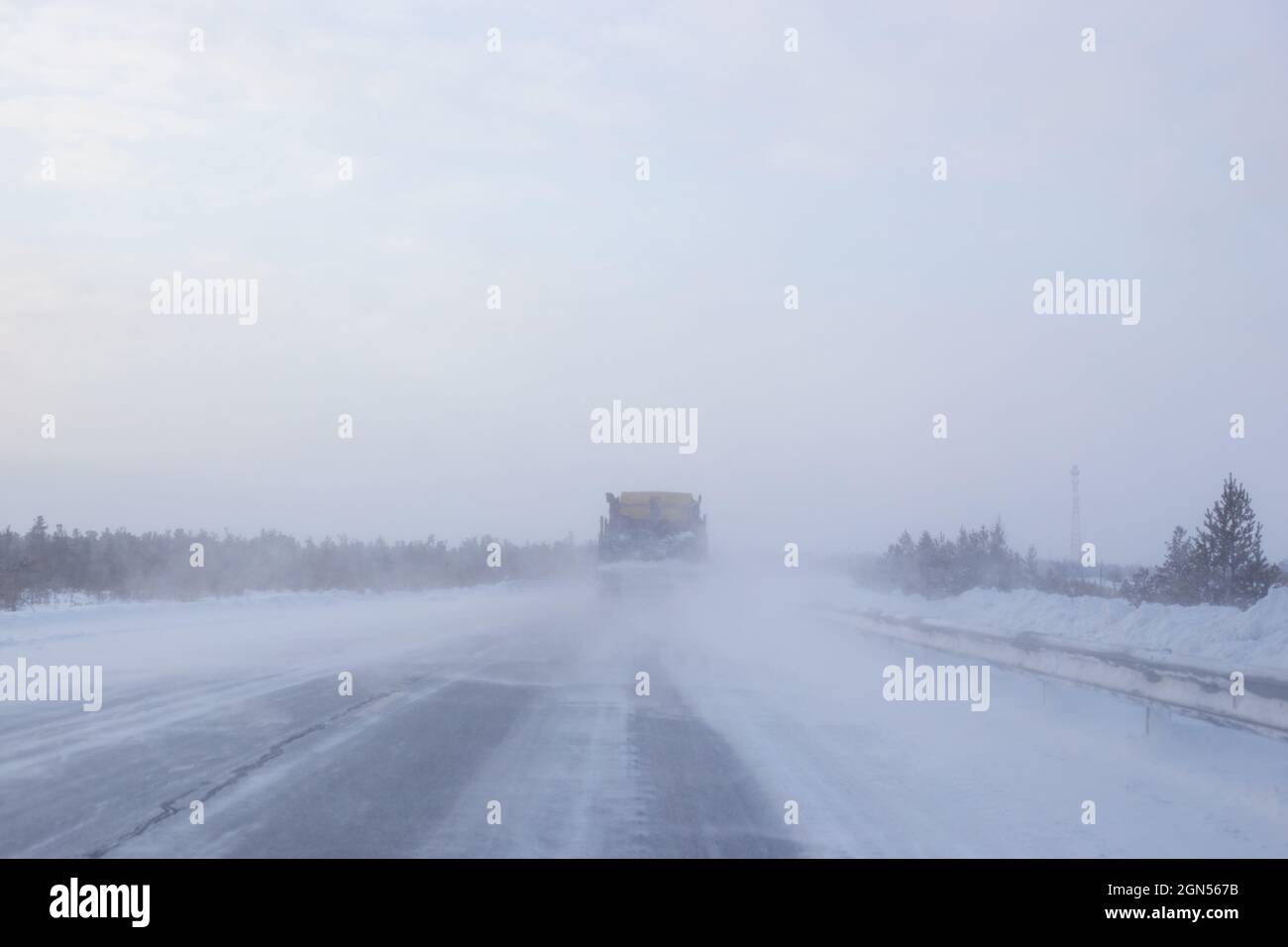 los coches van en una carretera de invierno con poca visibilidad, clima y tormenta de nieve Foto de stock