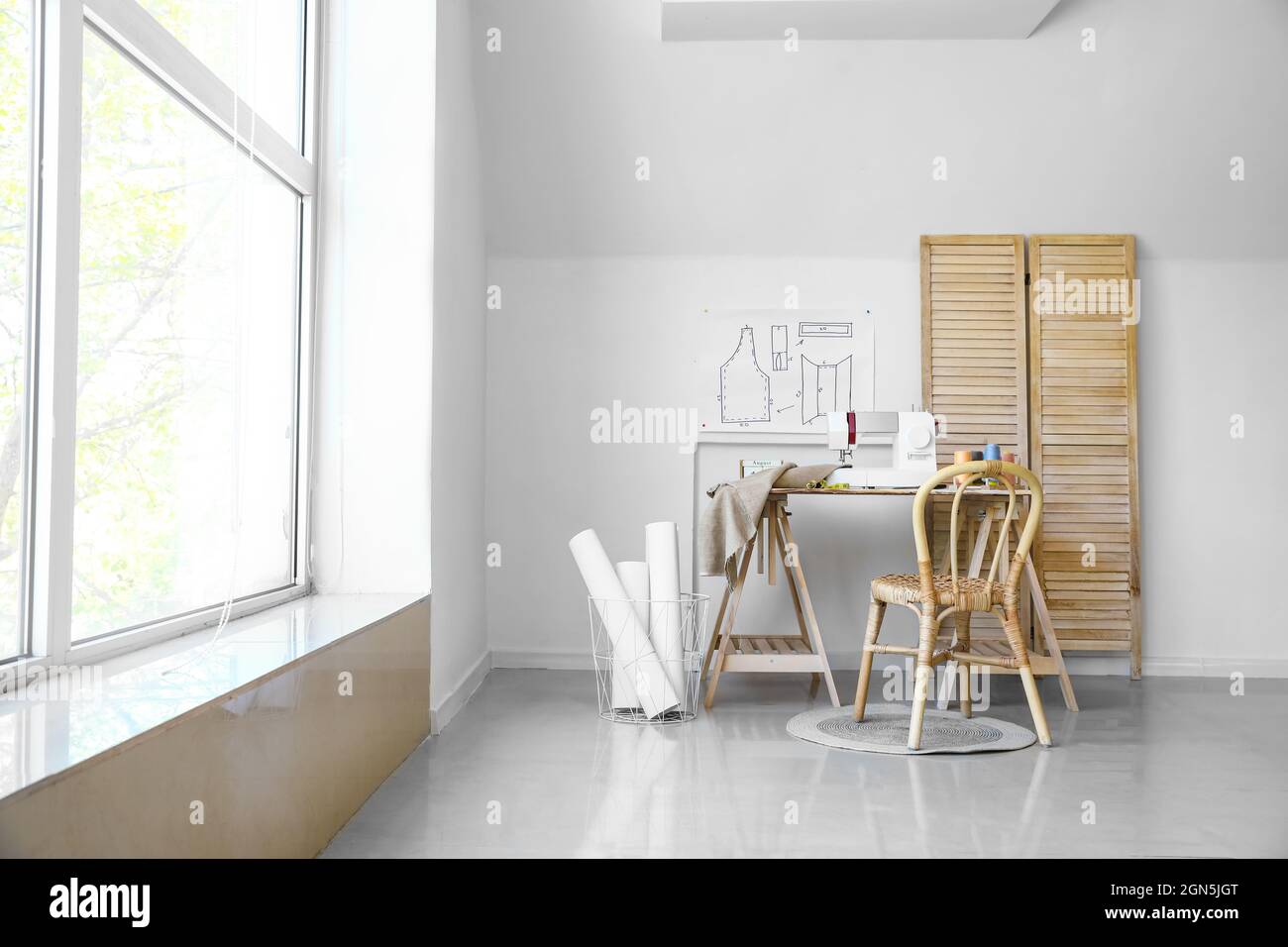 Lugar de trabajo de Tailor con máquina de coser cerca de la pared de luz  Fotografía de stock - Alamy
