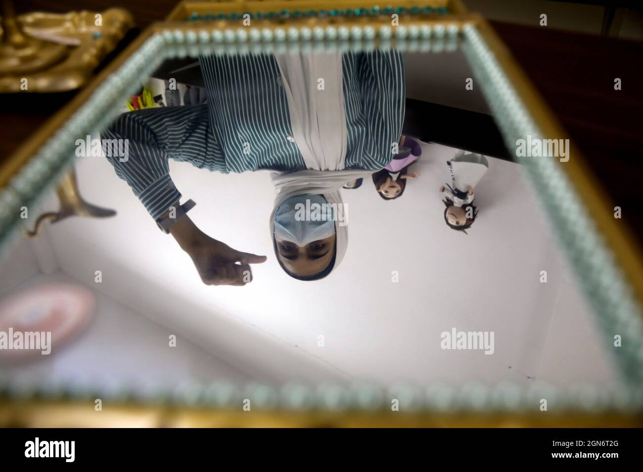 Un estudiante palestino sordo se refleja en un espejo reciclado durante una clase de artesanía antes del Día Internacional de las Lenguas de Señas, en una escuela para sordos en Naplusa, en la Ribera Occidental ocupada por Israel el 22 de septiembre de 2021. Foto tomada el 22 de septiembre de 2021. REUTERS/Raneen Sawafta Foto de stock