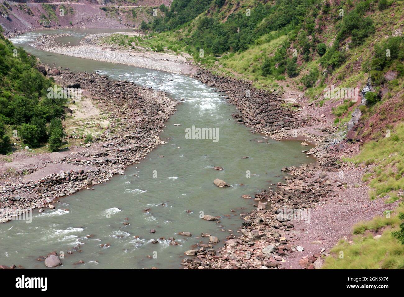 Río pequeño que fluye sobre las rocas agua verde claro Foto de stock