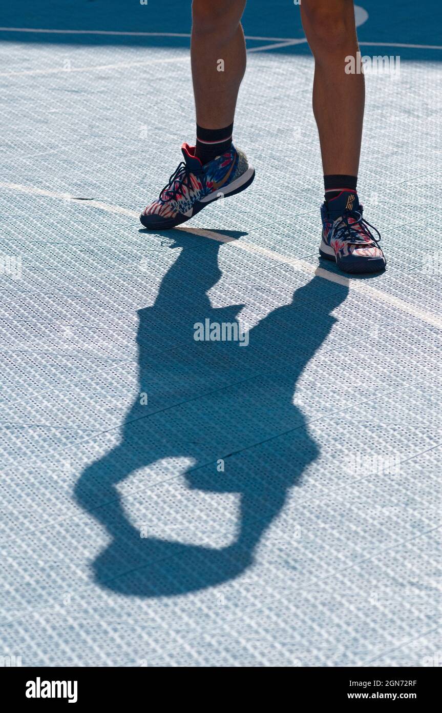 Hombre Yong jugando al baloncesto en la cancha Foto de stock