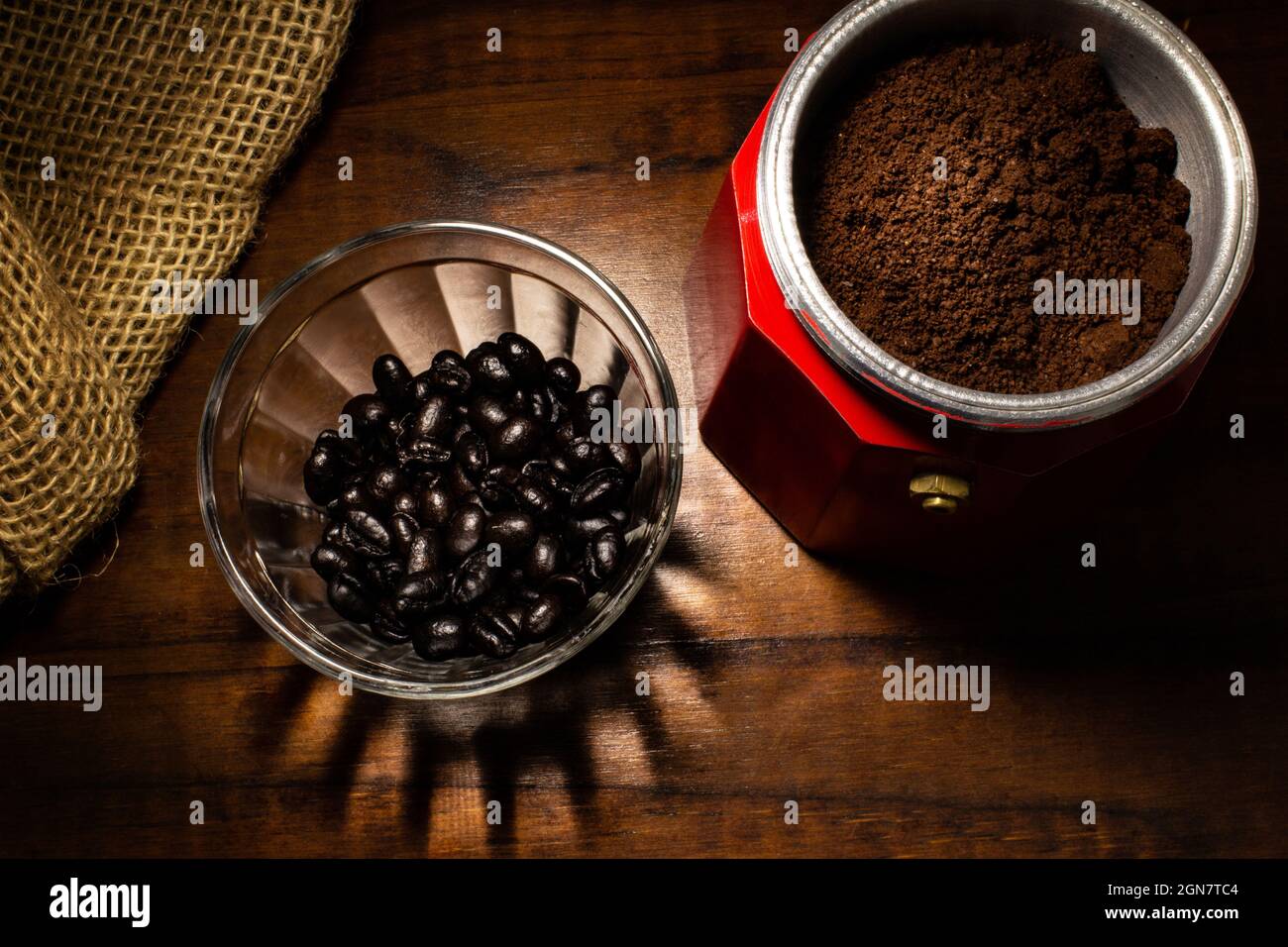 Café molido dentro de la cafetera italiana y una pequeña taza de cristal  llena de granos de café Fotografía de stock - Alamy