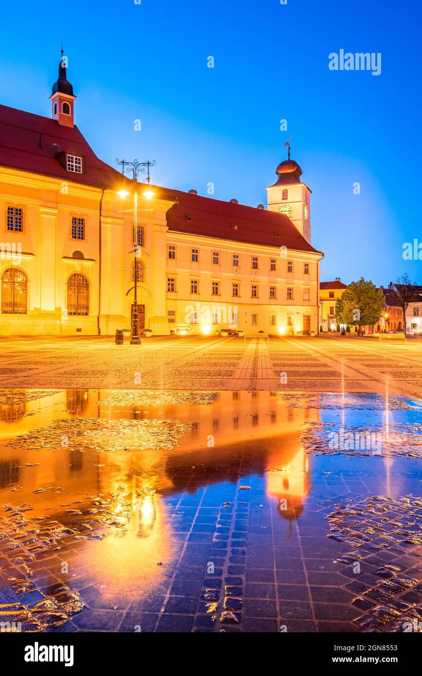 Sibiu, Rumania. Escena crepuscular con reflexión sobre el agua en la gran plaza de Transilvania. Foto de stock