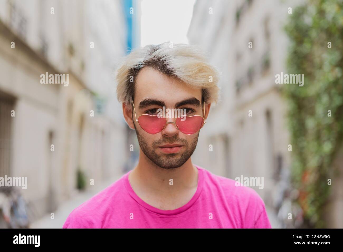 Joven hombre gay con gafas de sol rosas en forma de corazón Fotografía de  stock - Alamy