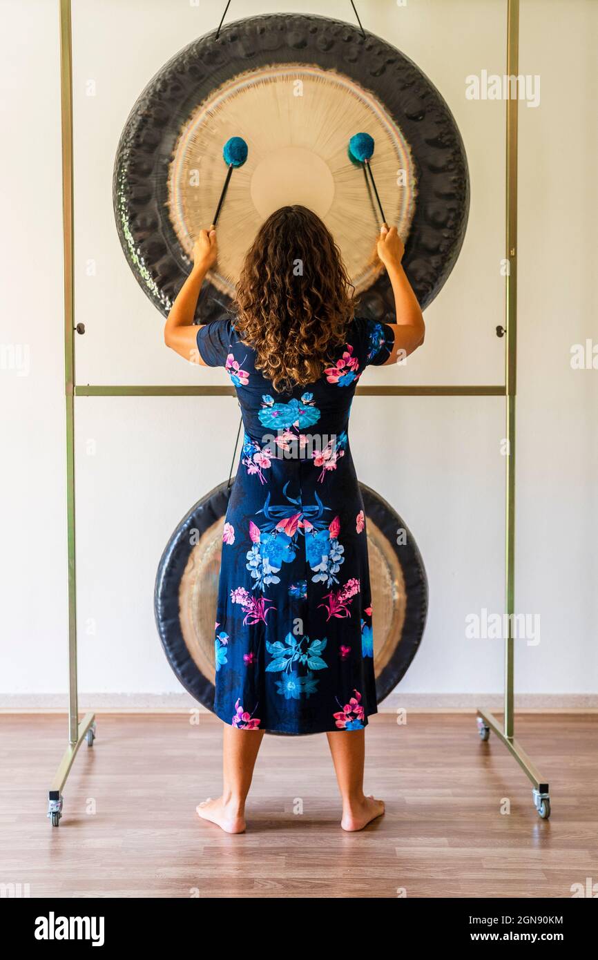 Terapeuta de sonido femenino tocando gong mientras está de pie en el  estudio Fotografía de stock - Alamy