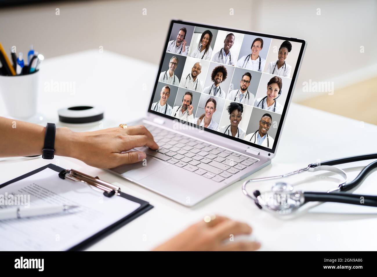 Doctor en Video Conferencia médica en línea con Equipo diverso de Trabajadores hospitalarios Foto de stock