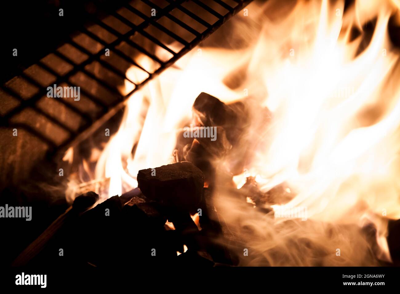 cerca del fuego en las llamas de la parrilla barbacoa fuego caliente cocinar Foto de stock