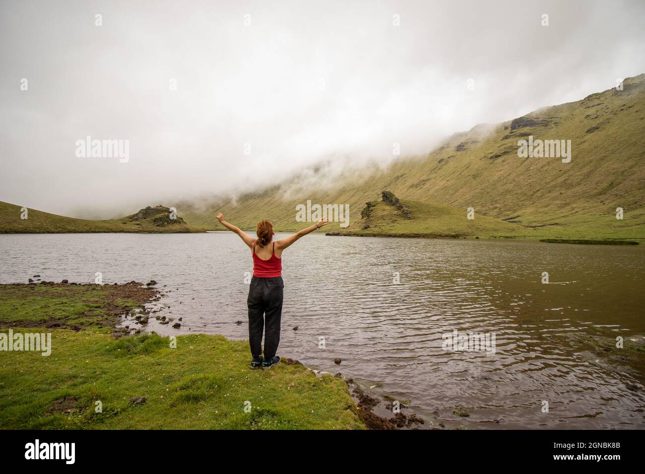 Mujer disfrutando de la naturaleza, isla Corvo, Azores, junto al lago, lujuria. Foto de stock